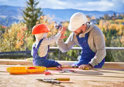 Un père et son fils en tenu de travail se tapant la main