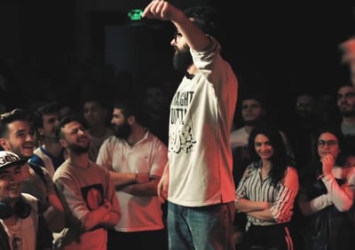 a man standing on a stage in a rap battle in the middle east