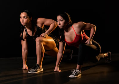 Studio shot of two muscular female athletes, doing a track and field pose