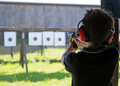 Young boy shooting static targets on the range