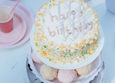 a cake with candles and cupcakes on a table