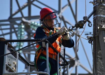 a man in a safety vest is working on a power line