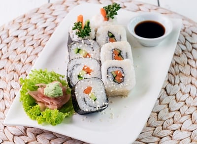 a plate with veggie sushi and sauce