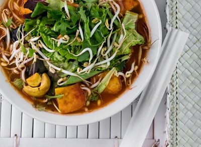 a bowl of soup with vegetables and noodles