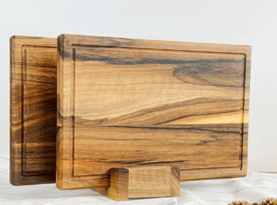 a wooden cutting board with a pine cone on top
