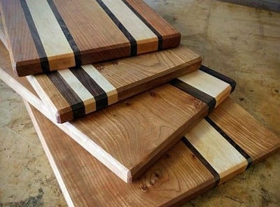 a pile of wood cutting board boards with a knife and knife