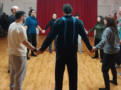 a group of people holding hands in a circle, classe di esercizi di bioenergetica
