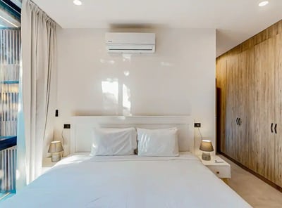 a bedroom with a bed and a large window