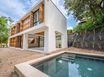 A house with a pool and a pool in the back in Tamarindo