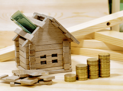 une maison avec des piles de pièces et une maquette de maison