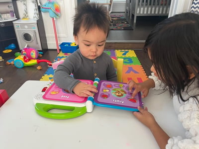 Photo of two children reading a book while at daycare.