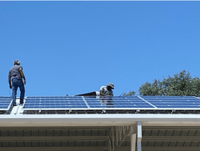 Two of our employees installing solar panels