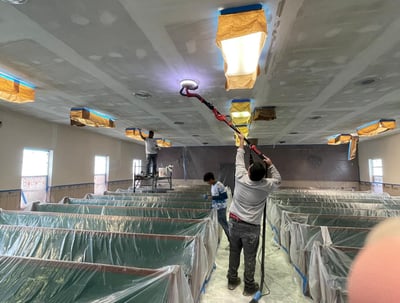 a man is painting a ceiling in a room