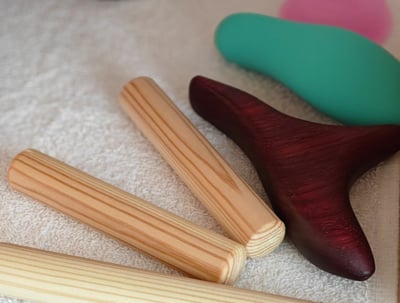 a variety of wooden massage tools on a shelf