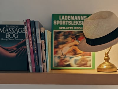 a hat on a shelf with books and a hat