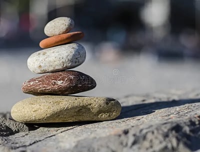 Foto de pedras empilhadas alinhadas representando equilíbrio atingido no consultório de psicologia.