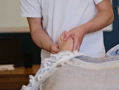 Thomas Busson pratique la réflexologie plantaire sur son client pour un soulagement immédiat