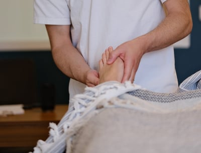 Thomas Busson pratique la réflexologie plantaire sur son client pour un soulagement immédiat