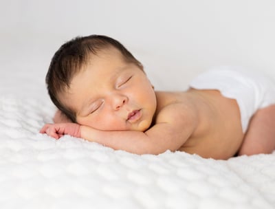 Sessió de fotos newborn a Girona amb una bebè recent nascuda dormint en estudi fotogràfic