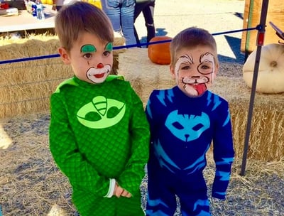 A Puppy and Clown Face Painting at a Pumpkin Patch
