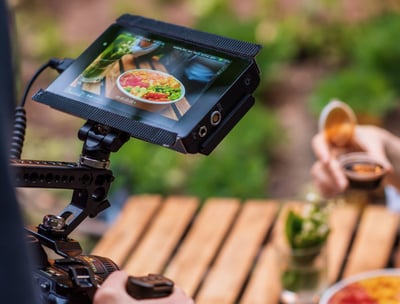 a person holding a camera and taking a picture of a person holding a drink