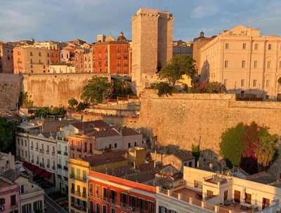 a cityscape of buildings and a castleof Cagliar in Piazza Yenne