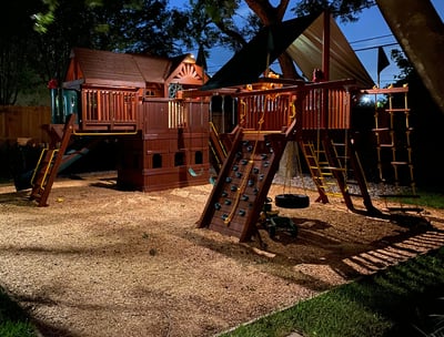 landscape lights installed on a swing set for a kids playground