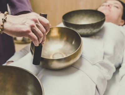 massage sonore au bols tibétains sur une femme allongée et habillée