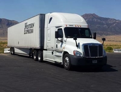 a semi truck with a dry van parked at a truckstop