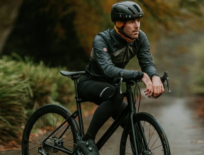 man presenting his helmet and his cycling jersey