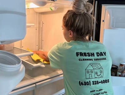 A professional cleaner thoroughly cleans inside of fridge