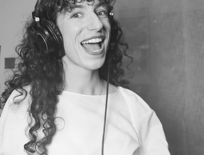 photo en noir et  blanc de aude fy en train de chanter avec casque sur les oreilles