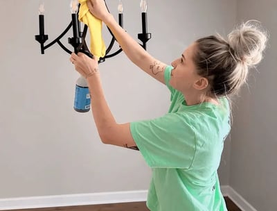 A professional cleaner carefully cleans a chandelier