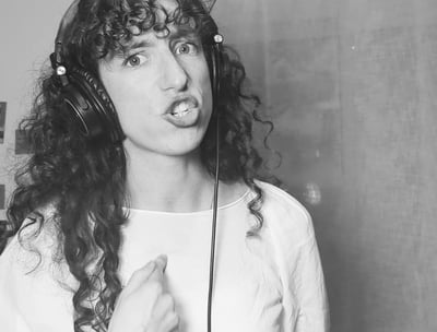 photo en noir et  blanc de aude fy en train de chanter avec casque sur les oreilles
