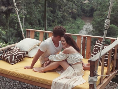 a man and woman sitting on a swing - swing