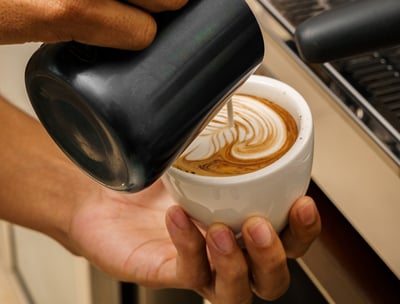 a person is pouring coffee into a cup