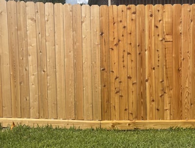 Side by side before and after oil based clear sealant application on a new wooden fence.