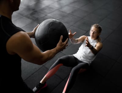 a man and woman doing a medicine exercise