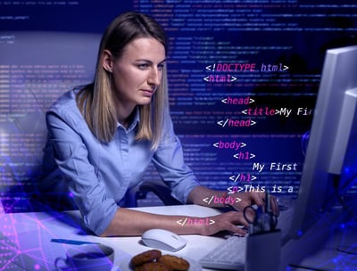 a woman sitting at a computer desk with a laptop