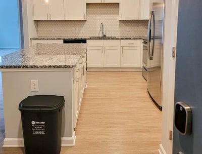 a kitchen with a trash canister and trash canisters