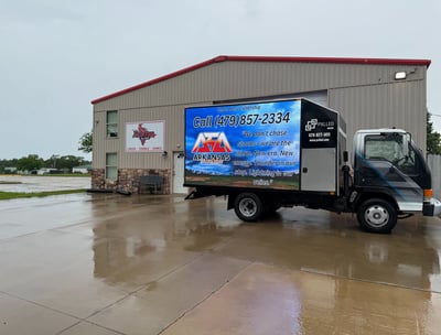 Mobile advertising truck parked at business featuring client digital signage campaign on LED truck
