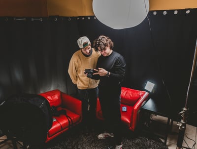 Two men in a podcast studio setting up podcast production services.