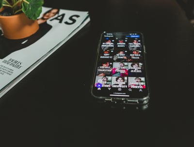 A phone displaying Instagram reels and social media clips for podcasts.