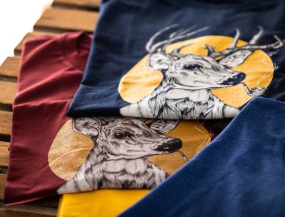 Two graphic t-shirts featuring a stylish deer smoking a pipe, printed design