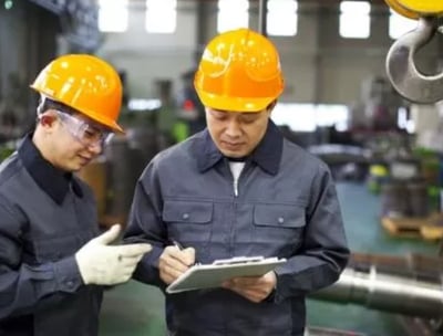 two men in hard hats and hard hats are standing in hongmeng tractors factory