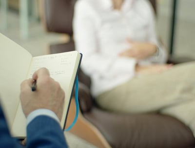 a man and woman sitting in chairs in a waiting room