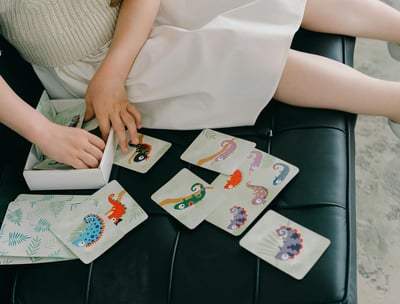 a girl sitting on a bench with a card game