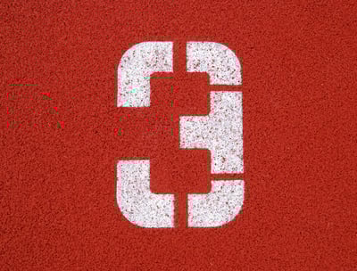 a number three on a red surface of a tennis court