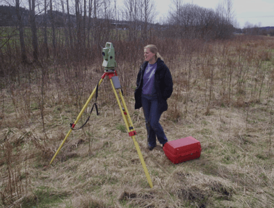 a woman in a field with a tripod and a tripod