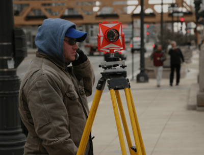 a man in a blue jacket and a camera on a tripod